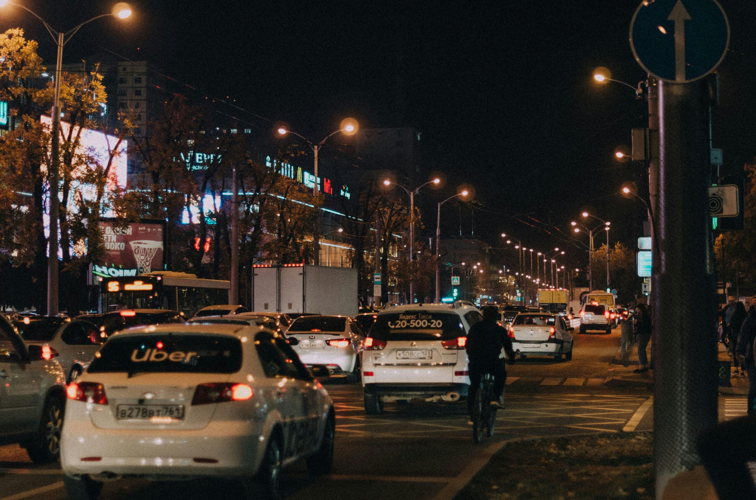 Busy nighttime scene of urban life and traffic in Krasnodar, Russia city center.
