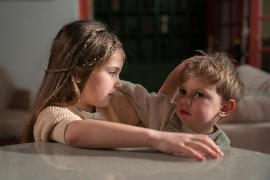 Heartwarming moment of a brother and sister showing affection indoors, embodying sibling love.